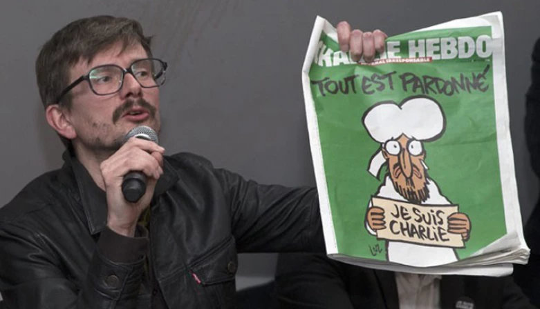 O cartunista Luz, novo diretor da revista, com a primeira edição do periódico depois do atentado que matou 12 pessoas da equipe. Na charge, o profeta Maomé chora sob uma manchete: