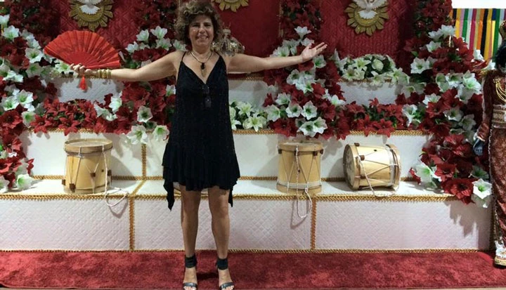Cantora na Casa do Maranhão em frente a uma instalação do cortejo do Divino Espírito Santo, festa popular do estado