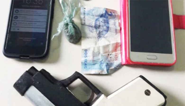 A arma, telefones e dinheiro foram apreendidos com os adolescentes.
