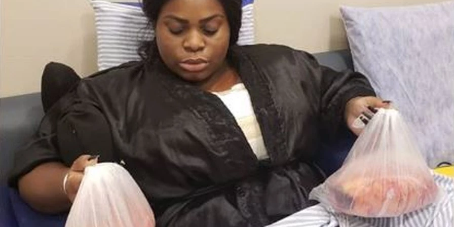Jojo Todynho posa segurando as mamas retiradas na cirurgia.