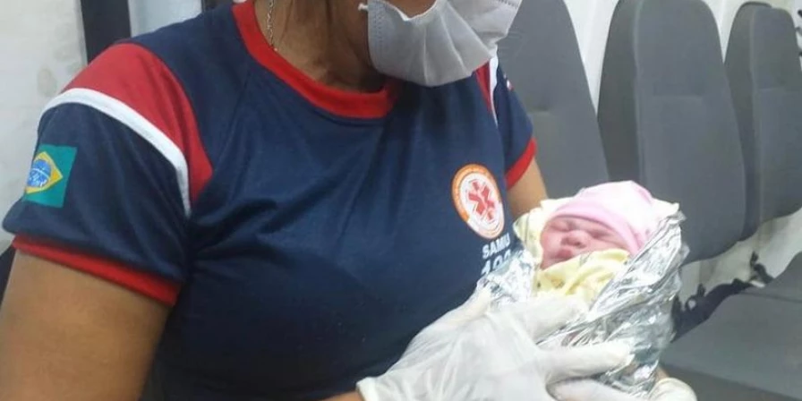 Pequena Maria Helena nos braços da técnica de enfermagem Iraci Bastos.