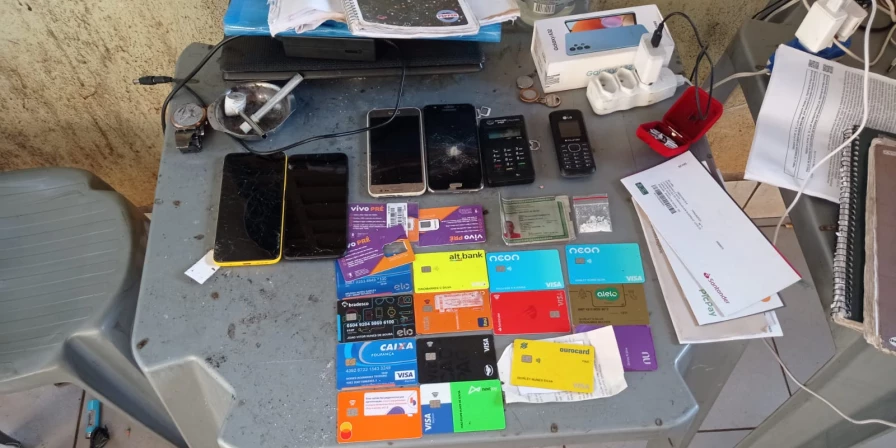 Celulares, caderno de anotação e cartões apreendidos durante a operação Anonymous.