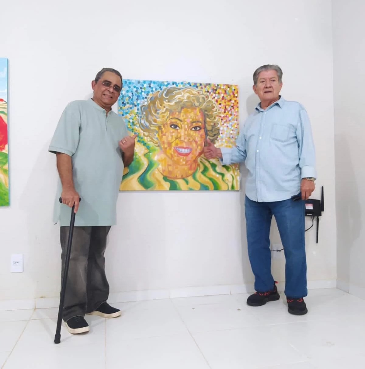 O maestro Zé Américo Bastos e o empresário Nan Souza apreciando o quadro “O som dos Lençóis”, do artista Joel DuMara para homenagear a cantora Alcione