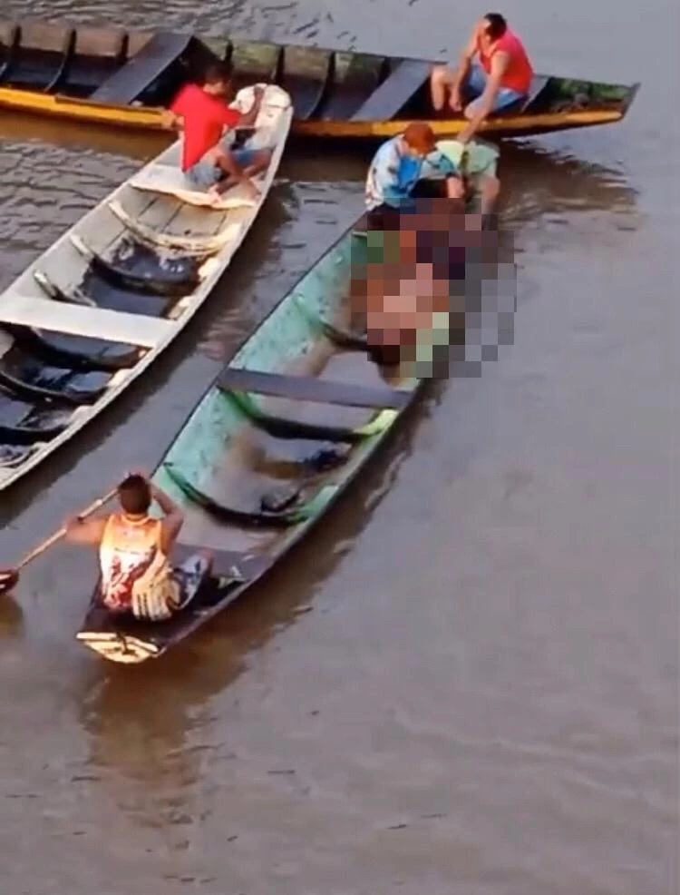 Corpo da vítima foi retirado do rio e levado em canoa. (Foto: Reprodução/Redes sociais)