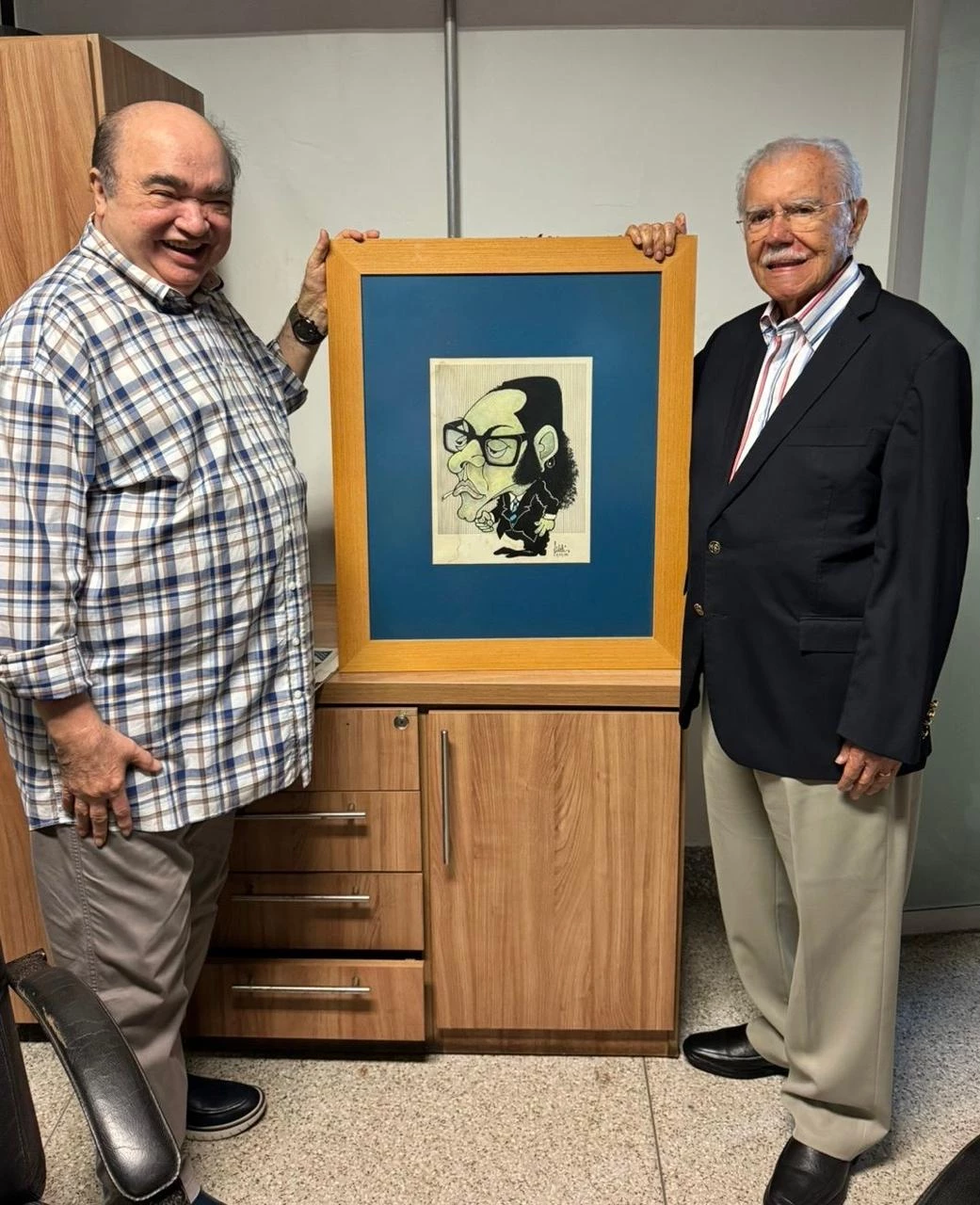 Numa tarde de boas lembranças, o ex-presidente José Sarney e o Repórter PH segurando a emblemática charge do poeta Bandeira Tribuzi, que fundou com Sarney o jornal O Estado do Maranhão, de saudosa memória, assinada pelo chargista Fidélis