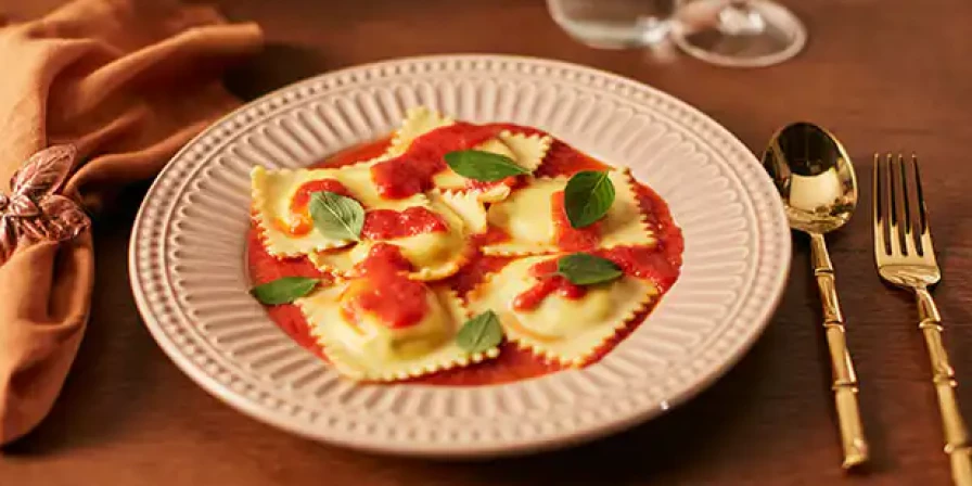 Ravióli com recheio de ricota ao molho de tomate.