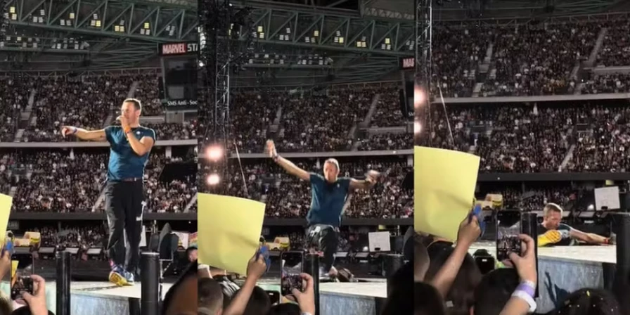Momento em que Chris Martin cai no buraco durante show.