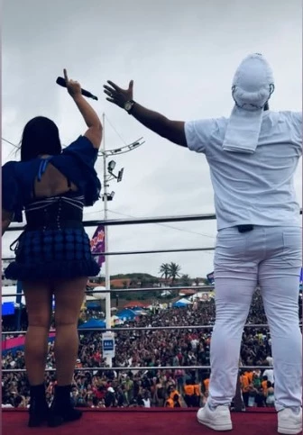 Erick Andrade e Elielma Vasconcelos acenam para o mar de foliões no corredor da folia, durante passagem do trio