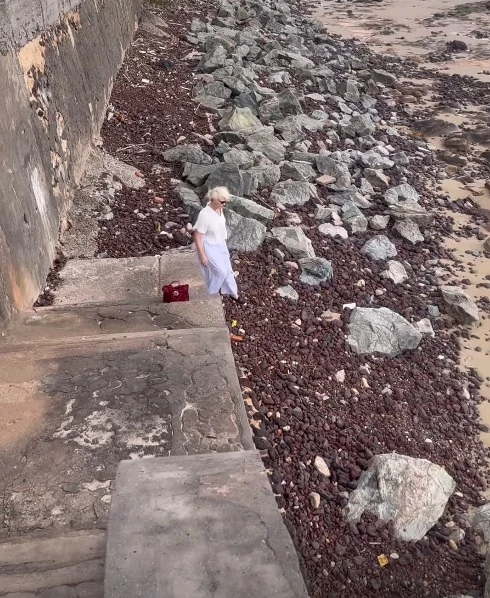 Atriz Júlia Lemmertz desce até a praia para coletar lixo sobre a areia, mandando um recado de que é preciso 'salvar o planeta'