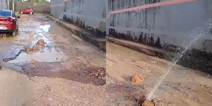 A rua, localizada perto do Cemitério Jardim da Paz, apresenta buracos, lamas e desperdício de água potável, devido a um cano estourado no meio da via. (Foto: Reprodução/ Juvêncio Martins)