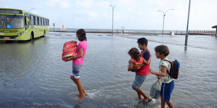 Maré alta não assusta moradores, que caminham pelas ruas da cidade de Raposa, na Região Metropolitana de São Luís