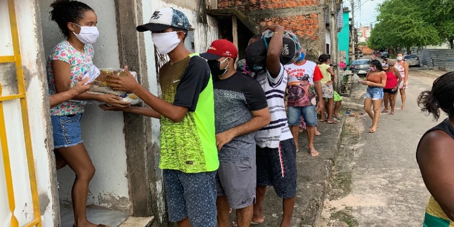 Populares afetados pela pandemia fazem fila para receber cestasfazem fila para