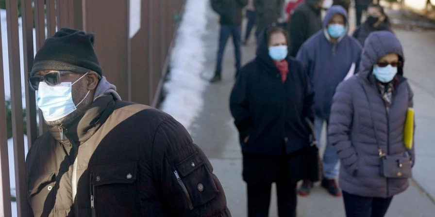essoas usam máscaras em fila de vacinação contra Covid-19 no Queens, em Nova York