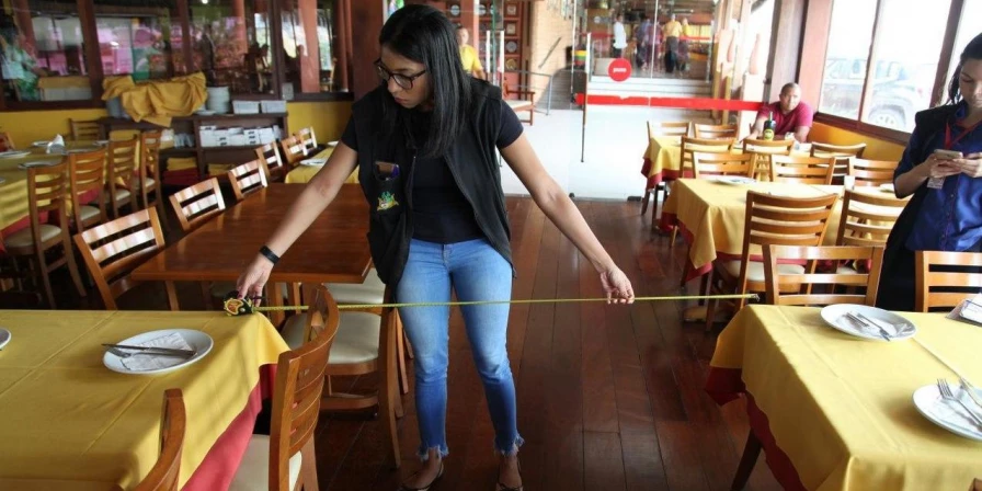 Técnico da Vigilância Sanitária faz medição do distanciamento de mesas em restaurante, durante fiscalização