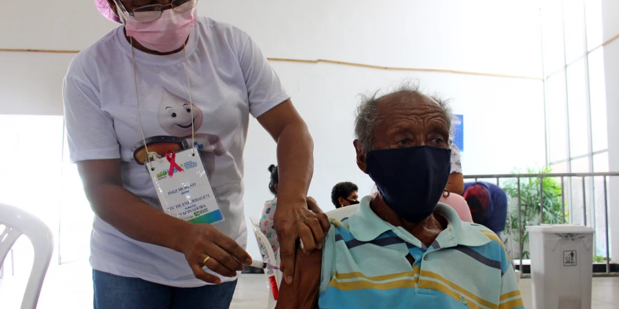 Idoso recebe a terceira dose de vacina contra a Covid-19